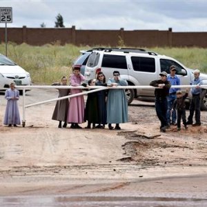 Image: Residents watch rescuers search along the Short Creek after a flash flood in Hildale, Utah